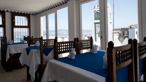 Una habitación de hotel con amplios ventanales, muebles de madera y vistas a la ciudad.