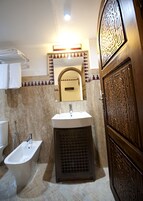 Un baño con bañera independiente, lavabo y espejo.