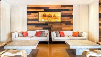 Una sala de estar moderna con dos sofás, una mesa de centro y una pared de madera con un estante que exhibe objetos decorativos.
