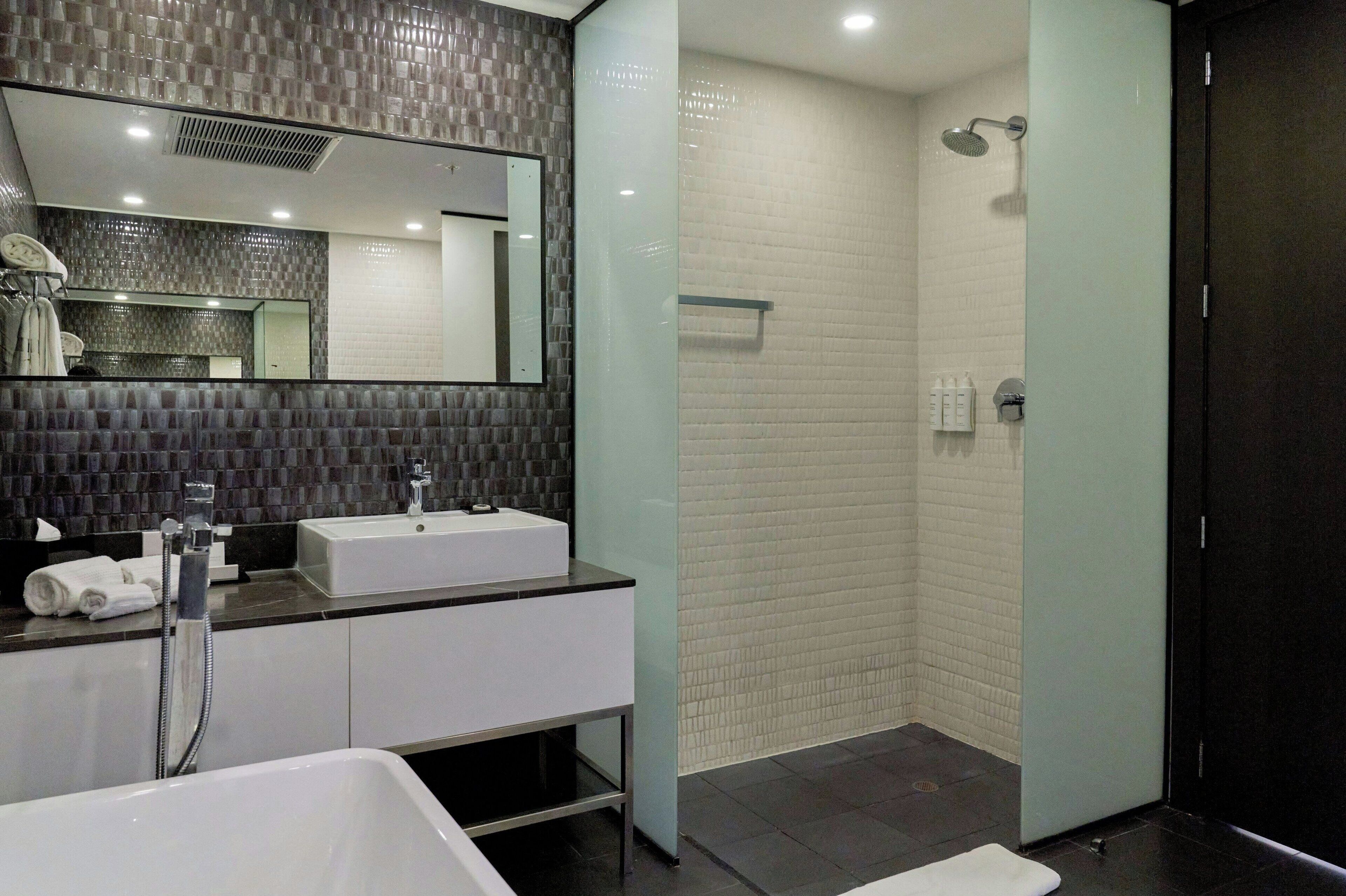Un baño moderno con dos lavamanos, un espejo grande y una ducha a pie.