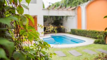 Una piscina al aire libre, sillones reclinables de piscina