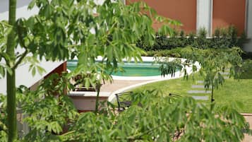 Una piscina al aire libre, sillones reclinables de piscina