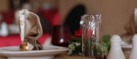 A table set with white plates, a clear glass pitcher, and white salt and pepper shakers.