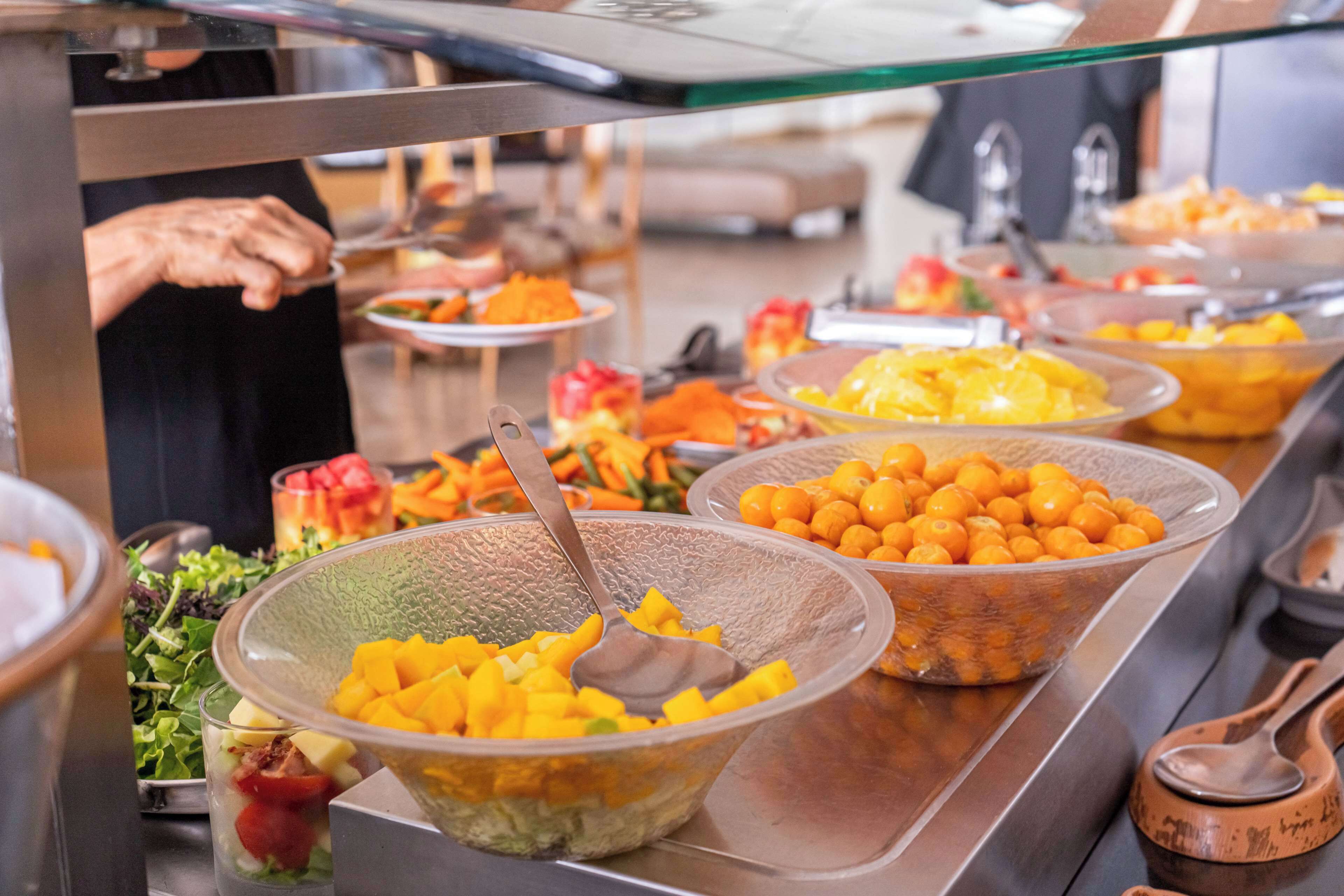 A buffet with various food items including fruits and salads.
