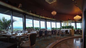 A restaurant with a panoramic view, large windows, and elegant chandeliers. - Hotel Sonesta Pereira (Pereira)