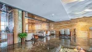 A modern lobby with a marble floor, seating area, and a reception desk. - Prestton Hotel (Jinan)