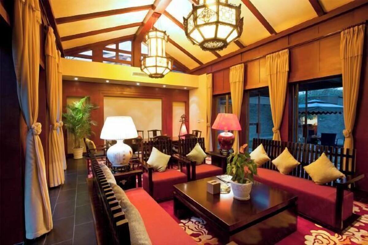 A hotel lobby with a seating area, a piano, and a large window.