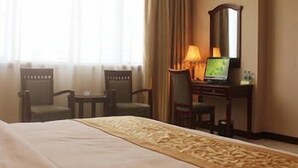 A hotel room with a large bed, a desk with a computer, a chair, and a window with curtains. - Vienna Hotel Huizhou Zhongkai Avenue (Huizhou)