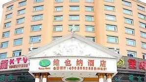 A hotel with a curved facade, multiple balconies, and a central entrance with a sign. - Vienna Hotel Huizhou Zhongkai Avenue (Huizhou)