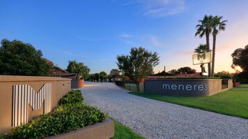 Un camino de grava que conduce a un edificio con un letrero que dice "meneres".
