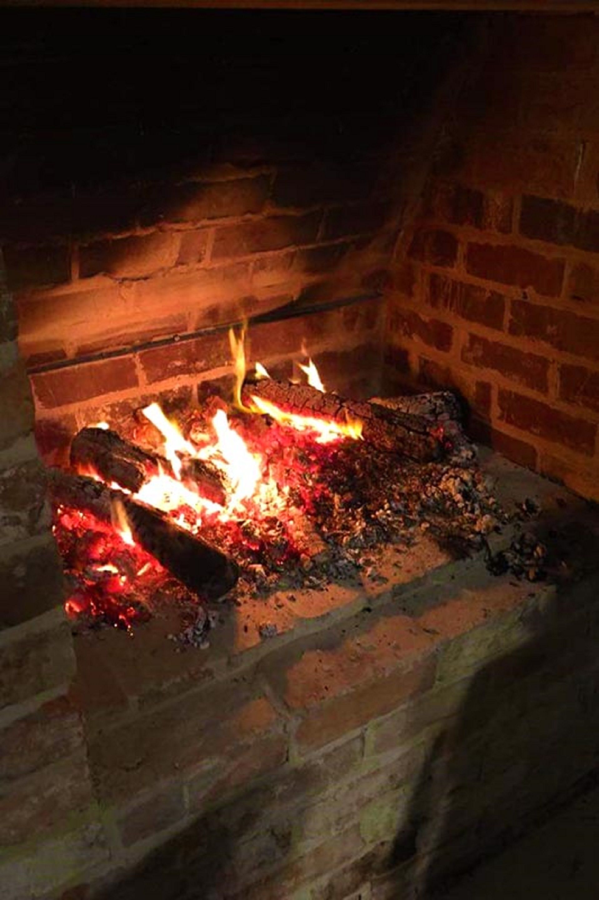 A fireplace with burning logs and flames.