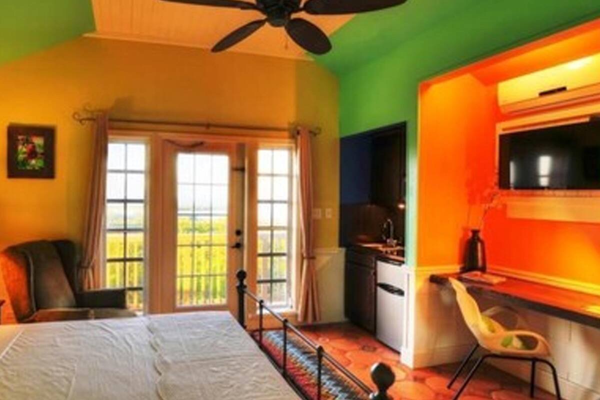 A hotel room with a bed, a desk, a chair, and a television.