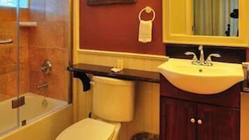 A bathroom with a bathtub, toilet, and sink.