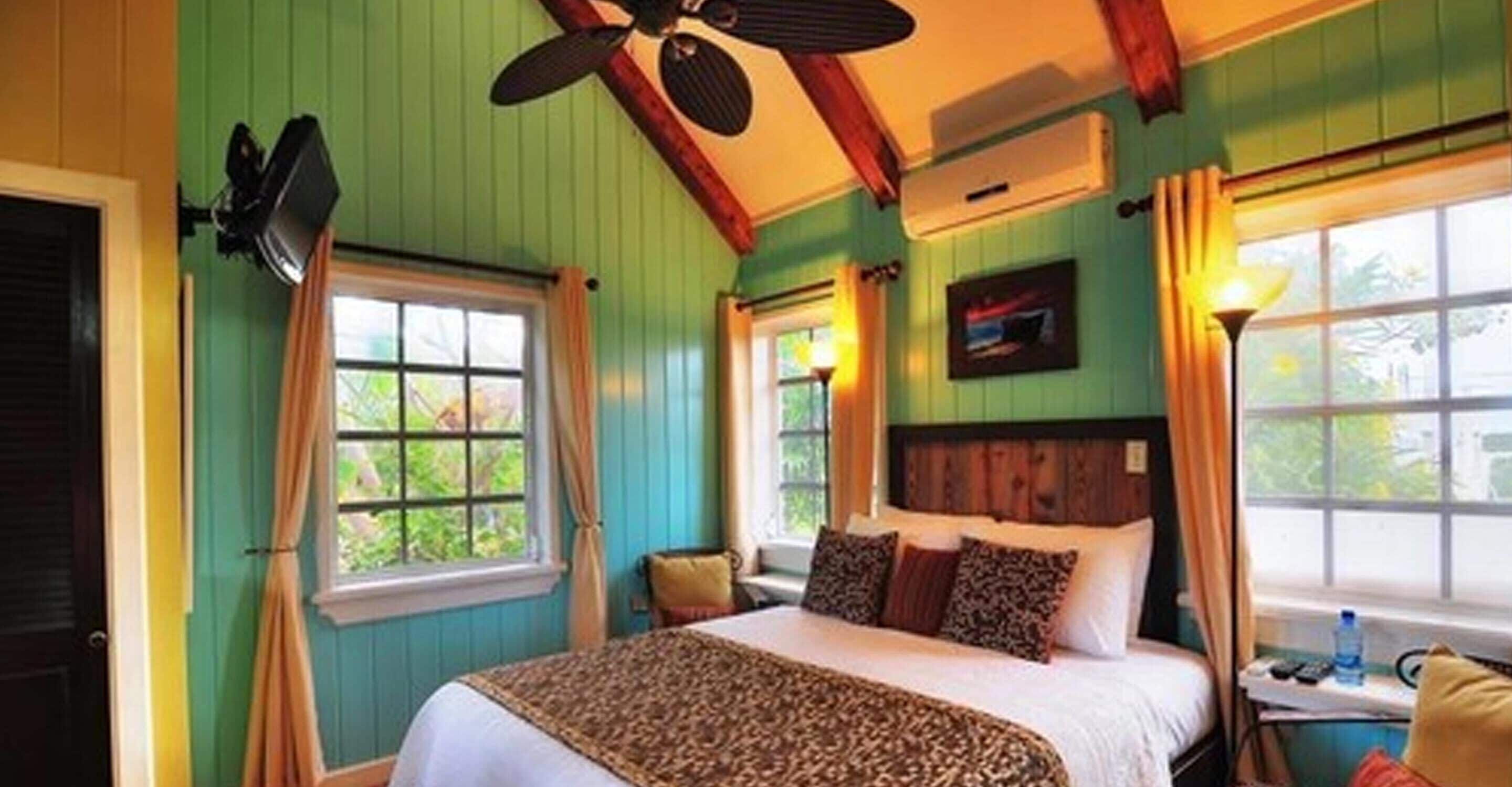 A room with a bed, a desk, a chair, and a window with curtains.