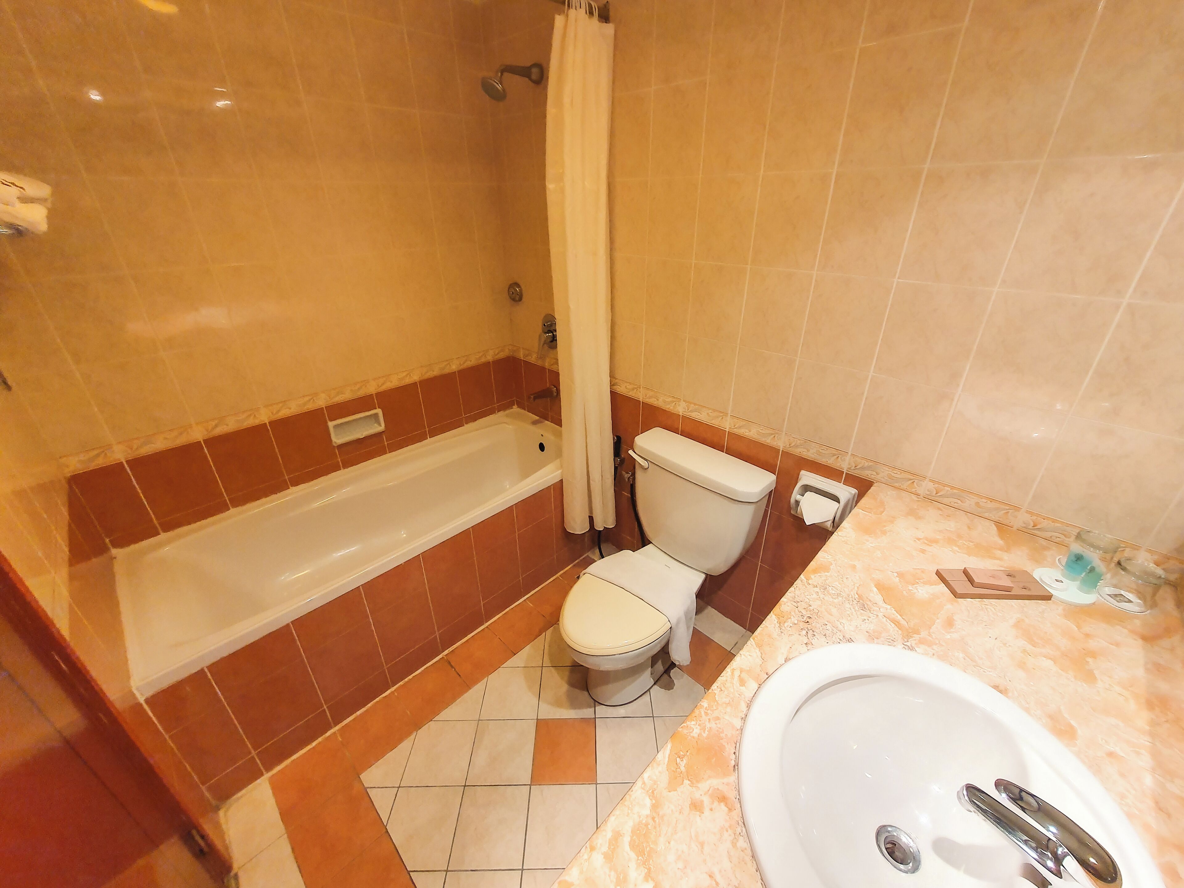 A bathroom with a bathtub, toilet, and sink.