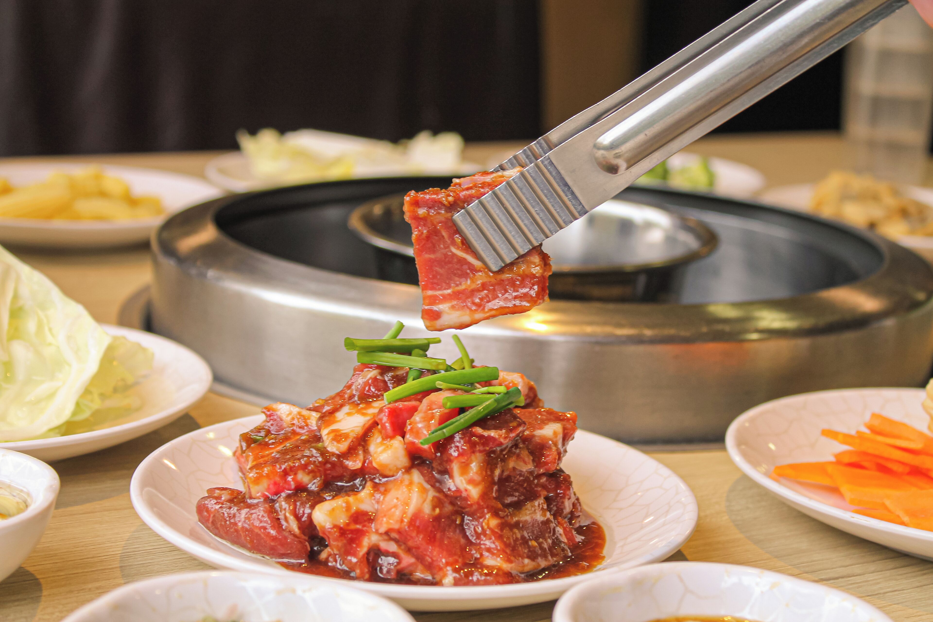 Una mesa de comedor con varios platos, incluyendo un plato con guiso de carne adornado con cebollines.