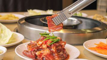 Una mesa de comedor con varios platos, incluyendo un plato con guiso de carne adornado con cebollines.