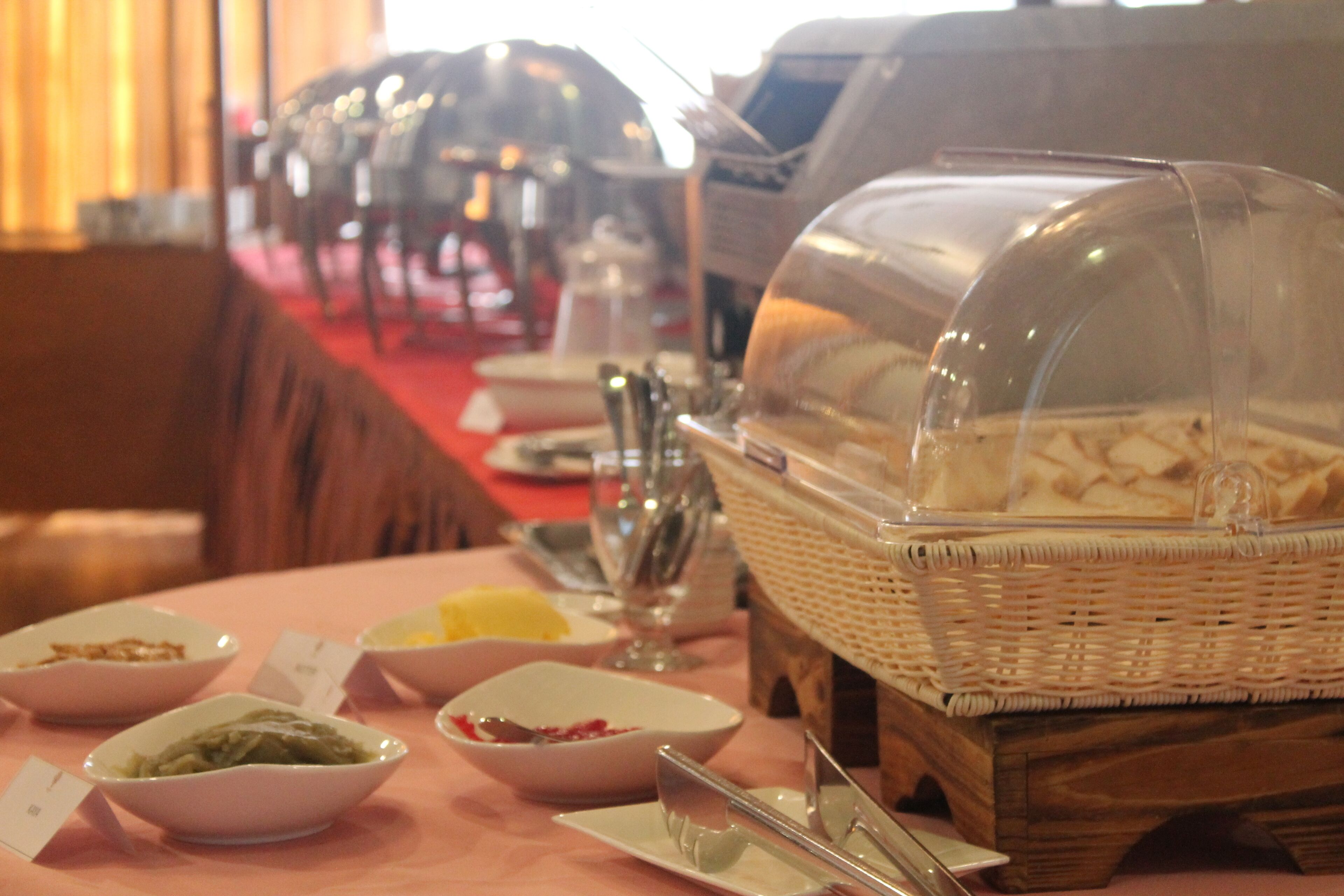 A buffet setup with various dishes and utensils on a table.