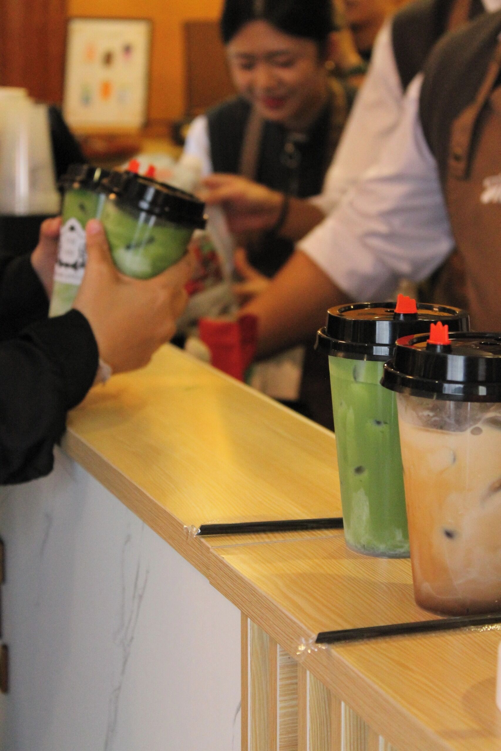 A counter with beverages and a wooden surface.