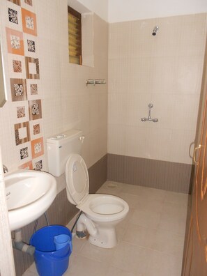Un baño con inodoro, lavabo y ducha.