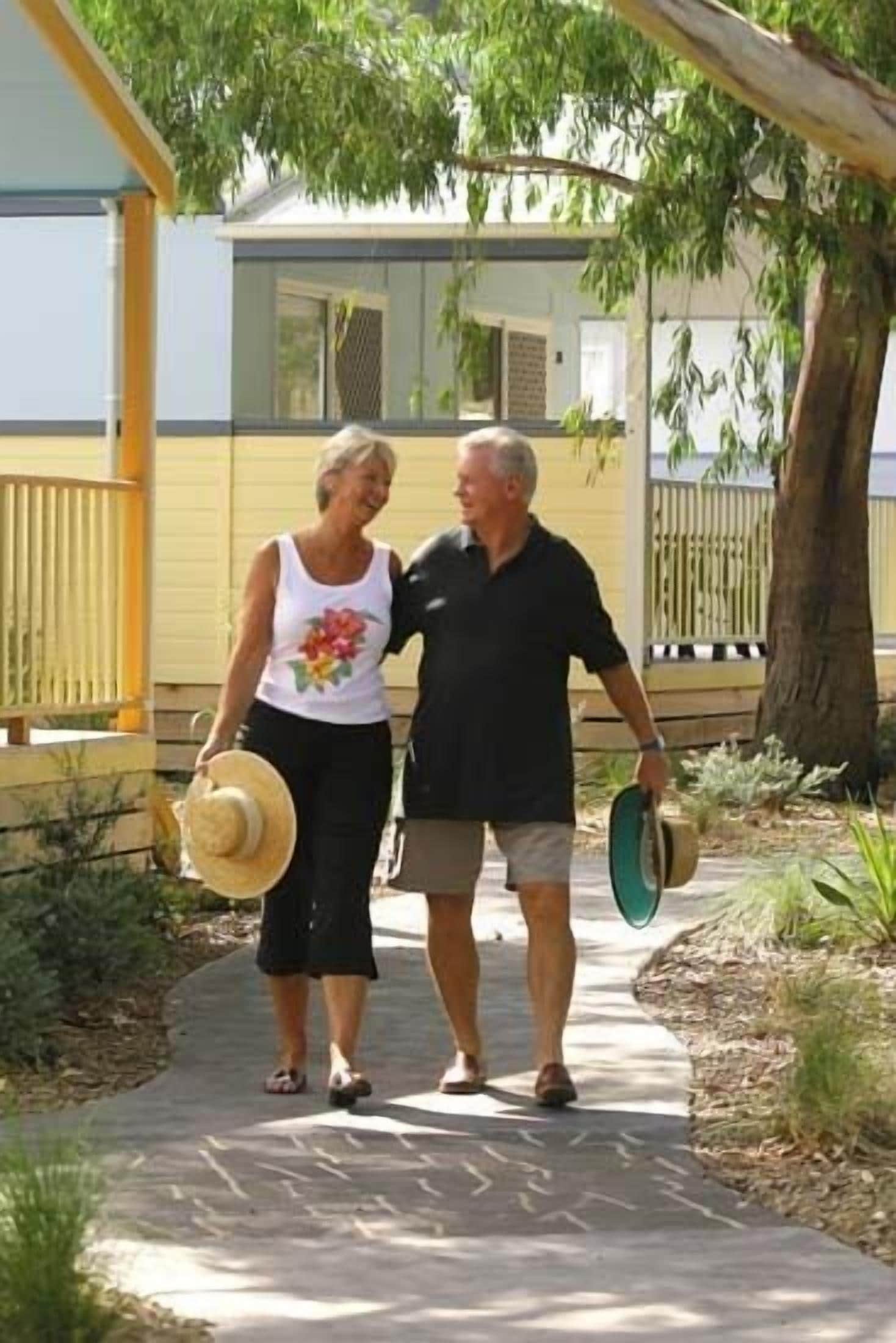 Two people walking on a paved path with a building in the background.