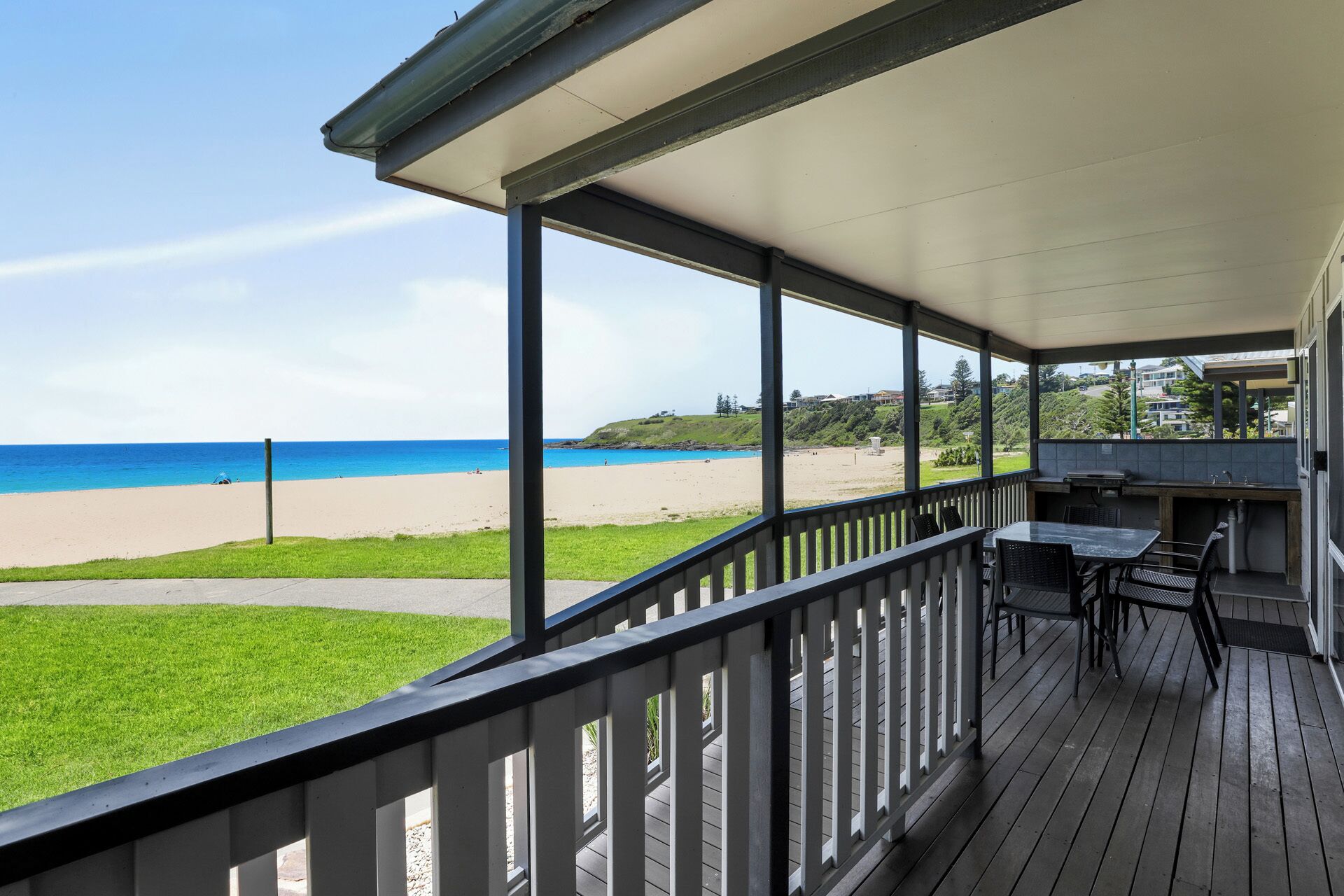 A covered outdoor area with a view of a beach and ocean.