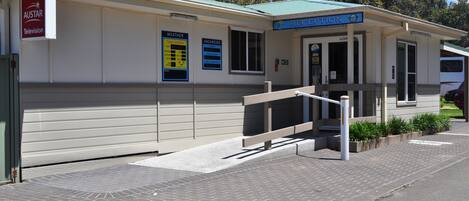 A reception area with a sign for 'Austar Television' and a 'Reception' sign above the door. There are weather and vacancies signs on the wall.