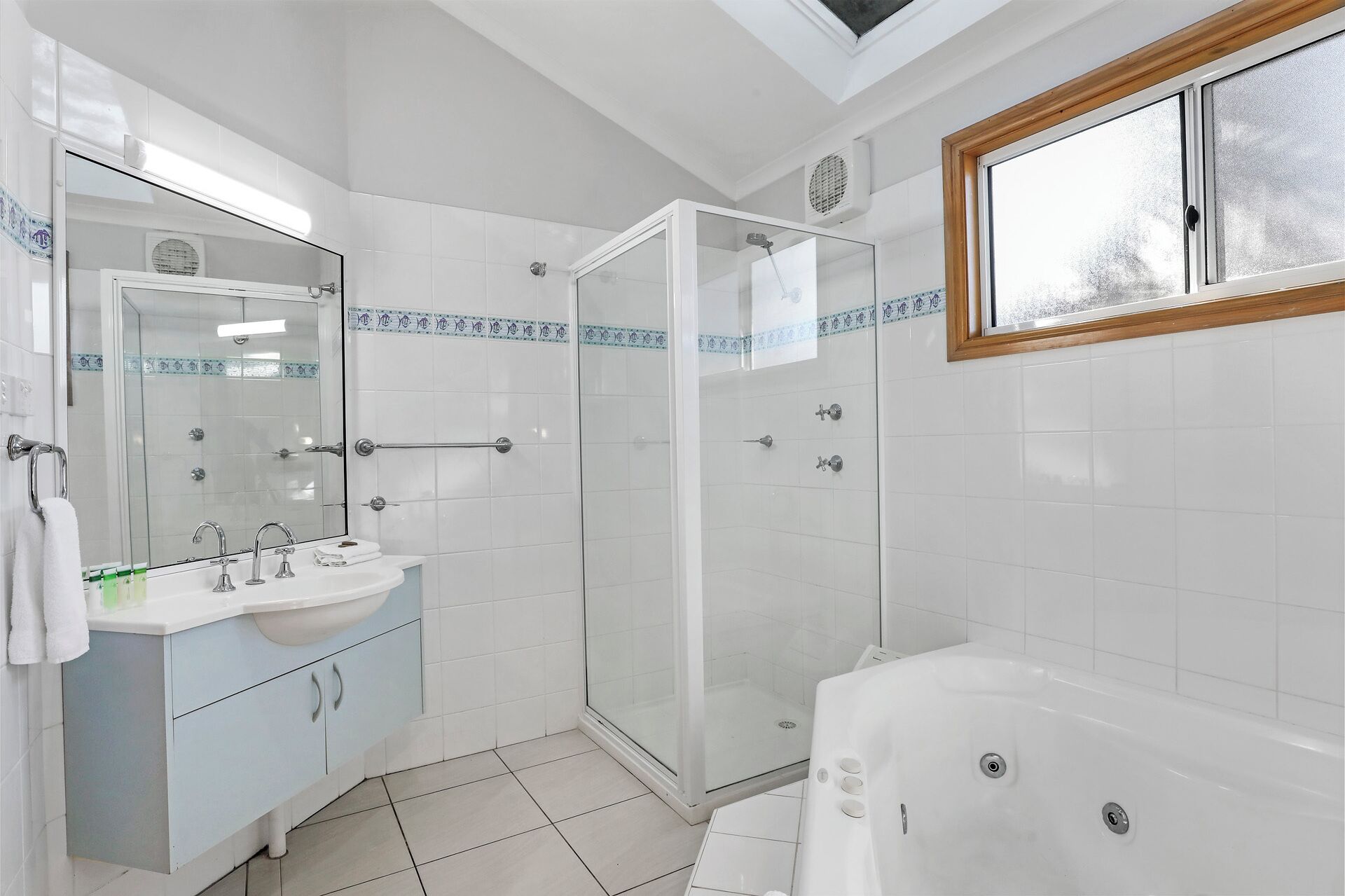 A modern bathroom with a glass-enclosed shower, a freestanding bathtub, and a vanity with a mirror.
