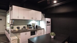 A compact kitchen with white cabinets, a built-in oven, and a refrigerator. - Fun Inn Taipei Hostel (Taipei)