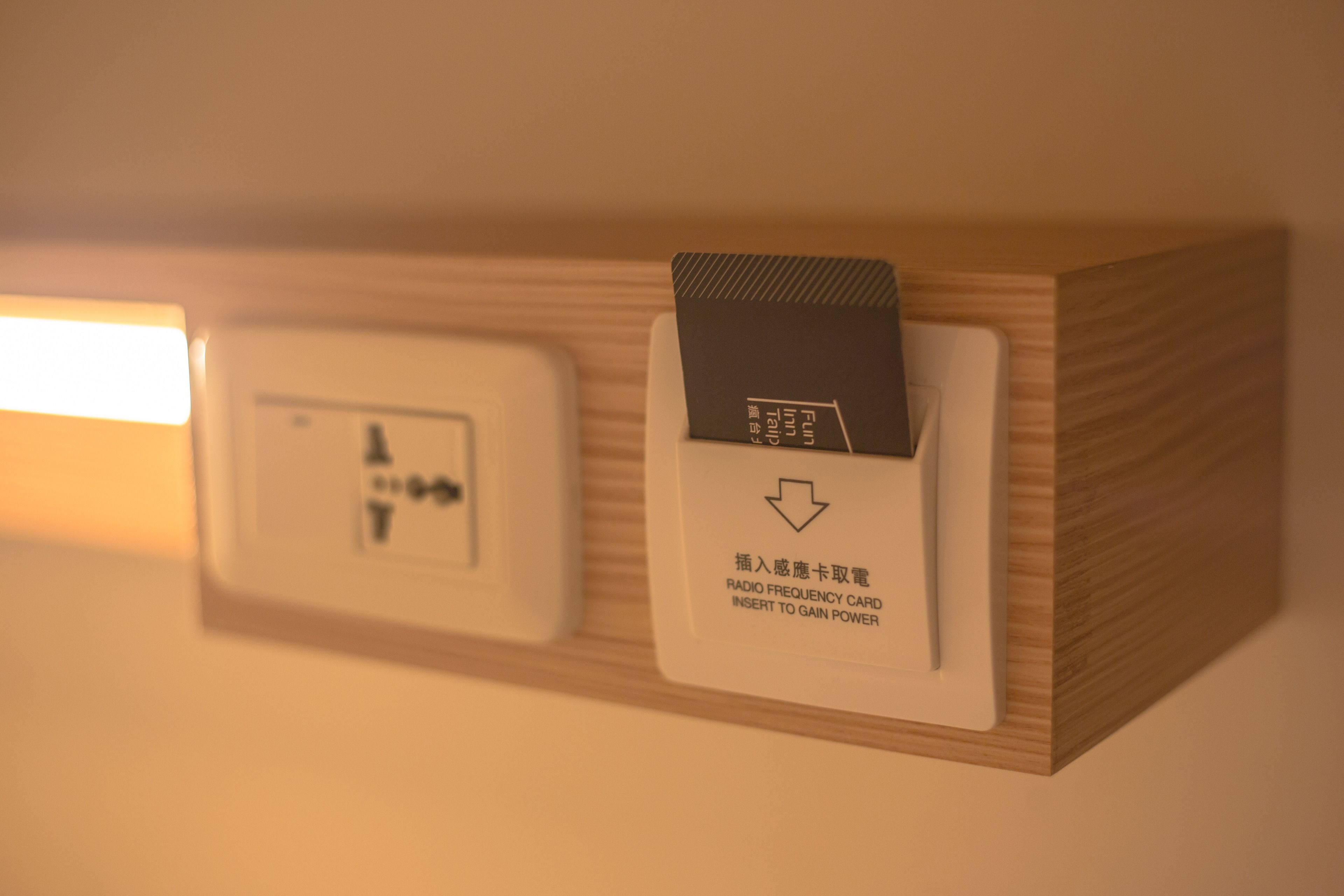 A wooden panel with a radio frequency card slot and a control panel with a power button.