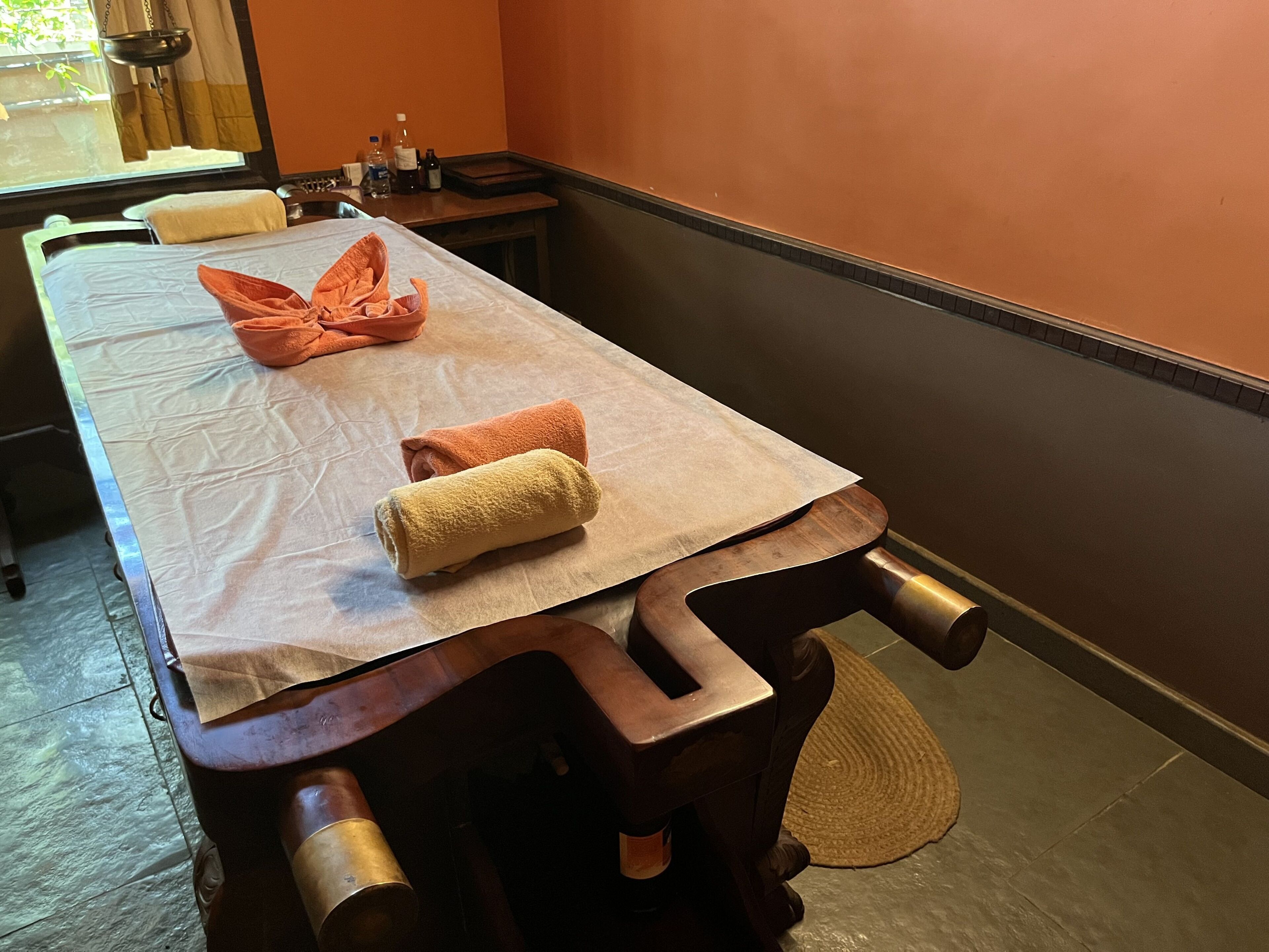 A massage table with towels and a bottle of oil.