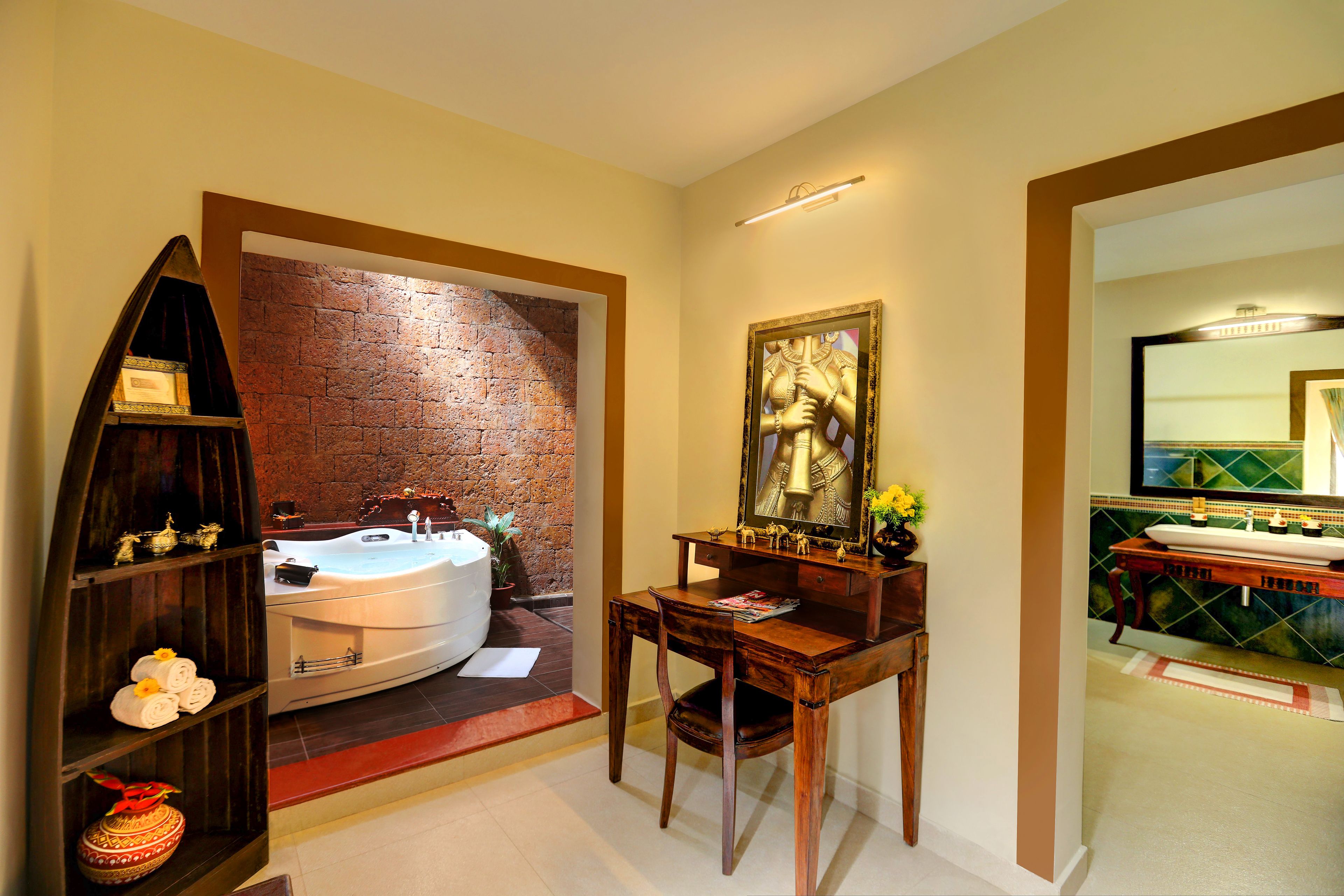 A bathroom with a bathtub, a wooden vanity, a mirror, and a brick wall.