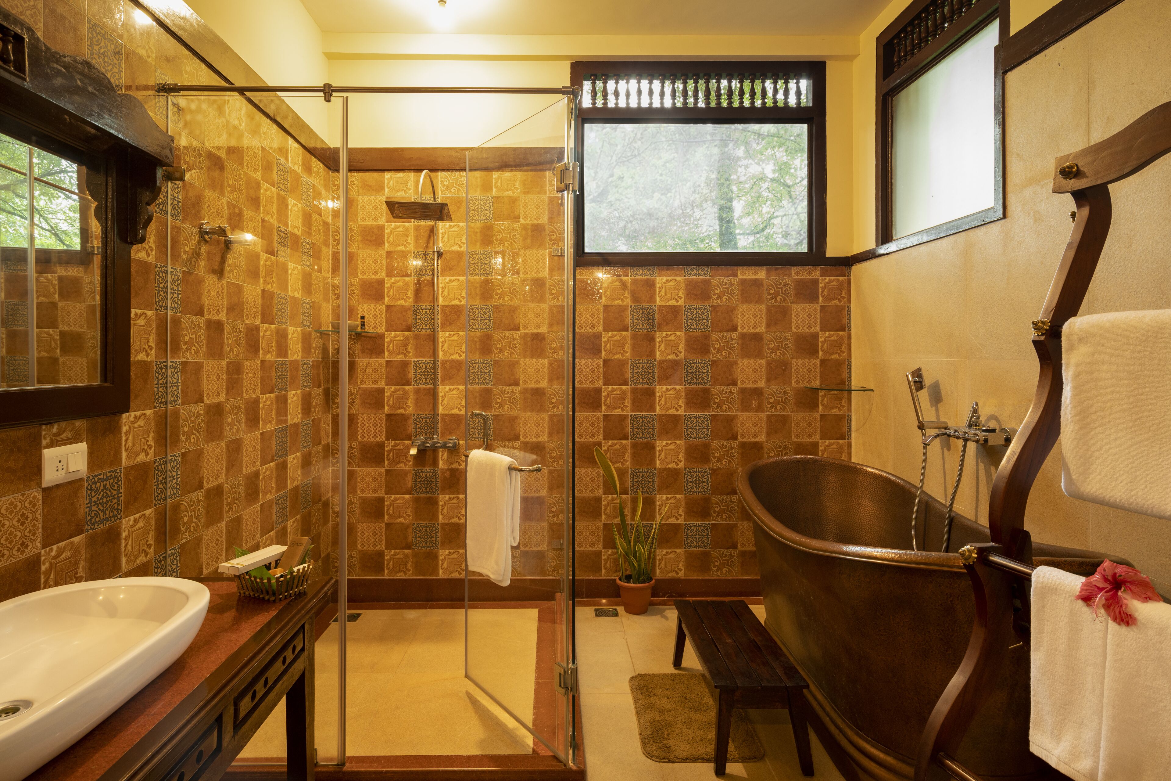 Un baño con ducha envuelta en cristal, una bañera independiente y un lavabo.