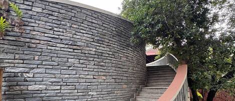 A stone staircase leading up to a building with a curved handrail.