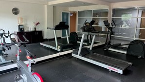 Uma academia com esteiras, elíptico e bicicleta ergométrica.