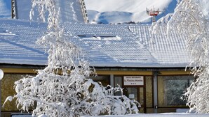 Un edificio cubierto de nieve con un letrero que dice 'Hotel Ristorante La Vecchia Miniera'.