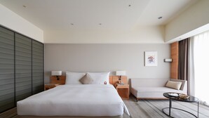 A modern hotel room with a large bed, a sofa, a small table, and a view of the outdoors. - HOTEL COZZI Ximen Tainan (Tainan)