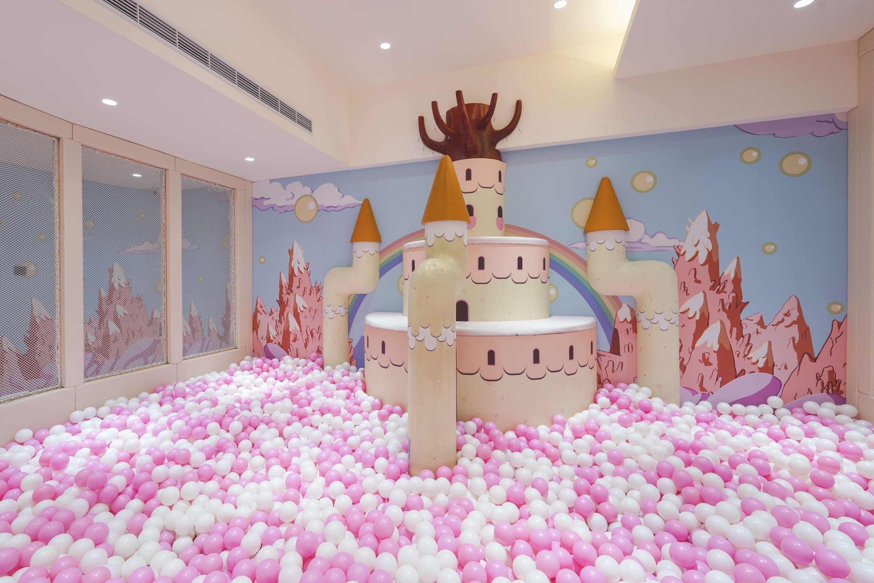Un espace de jeux avec une piscine à balles et une structure en forme de château.