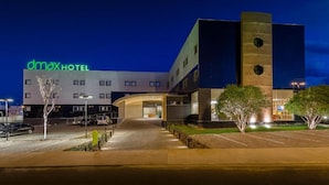 A modern hotel building with a prominent 'dmax hotel' sign, a parking area, and a well-lit entrance. - DMax Hotel (Marilia)