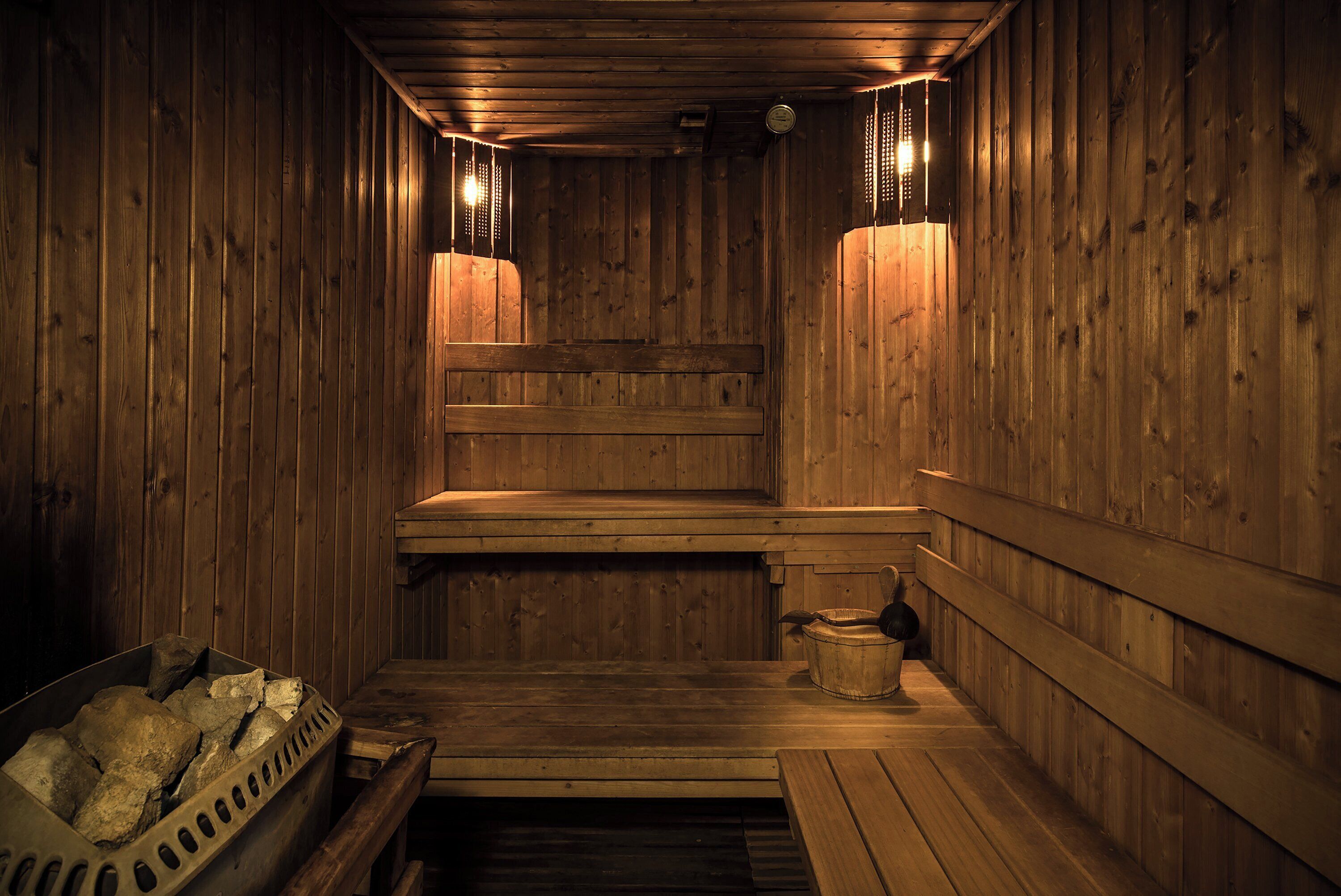 A wooden sauna with benches and a stone basin.