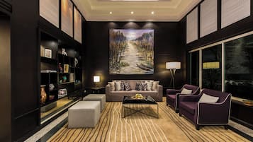 Una sala moderna con un sofá, sillones, una mesa de centro y una estantería.