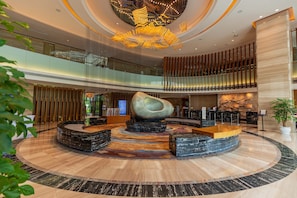 A spacious lobby with a central seating area, a reception desk, and a modern chandelier. - DoubleTree by Hilton Guangzhou Science City-Free Shuttle Bus Service During Canton Fair Period (Guangzhou)