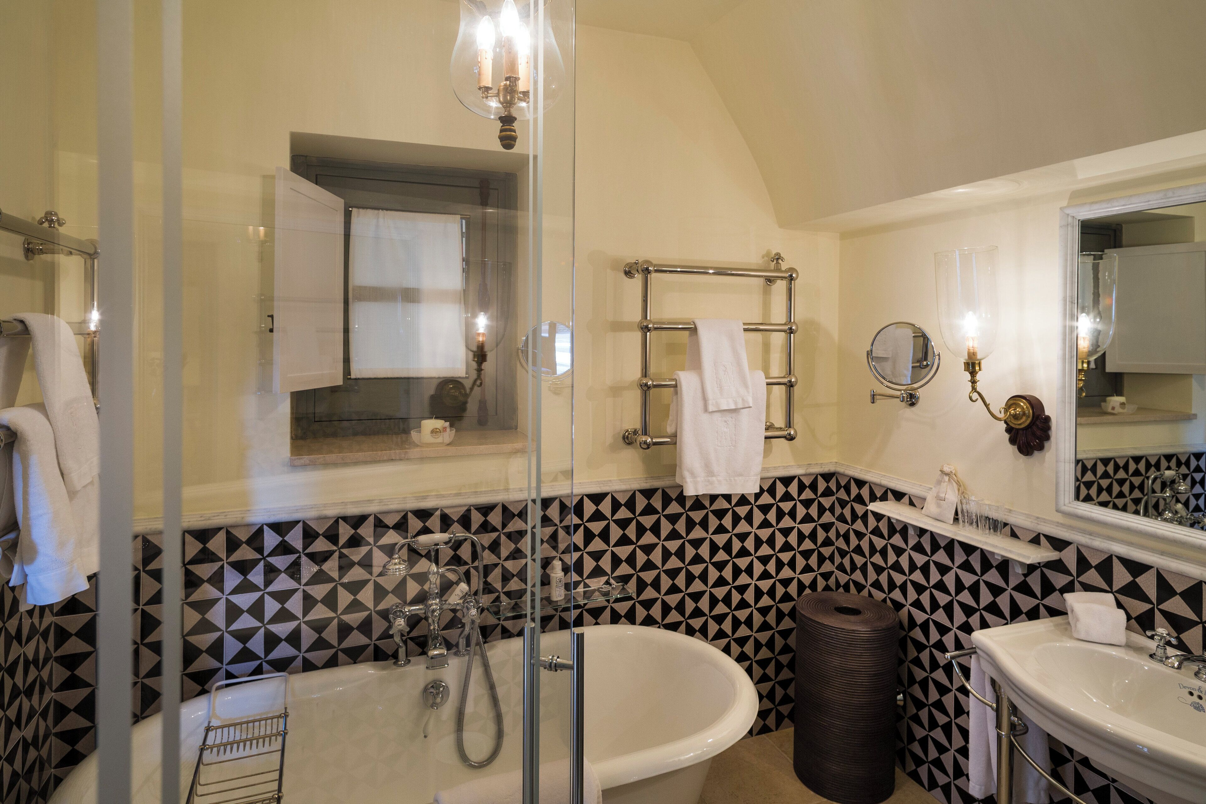 A bathroom with a freestanding bathtub, a glass shower enclosure, a vanity with a mirror, and a towel rack.