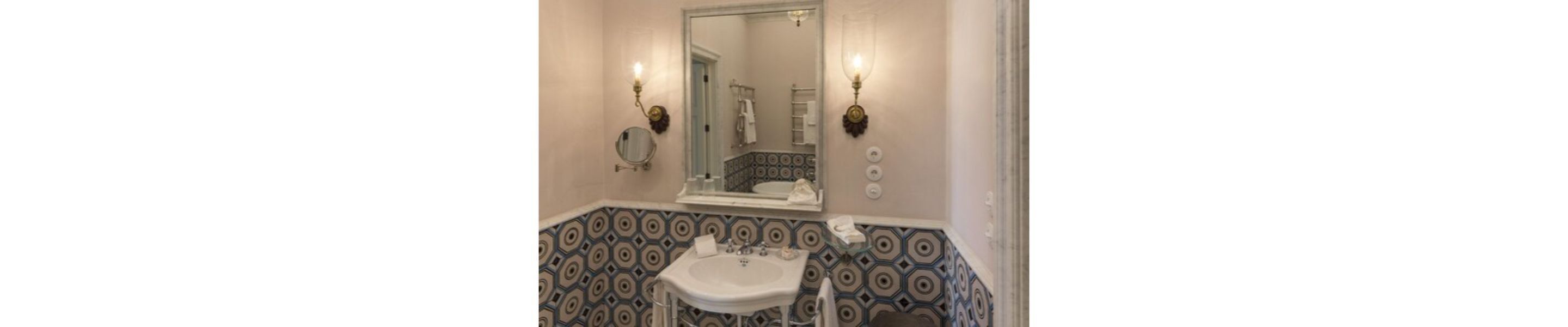 Ein Badezimmer mit Waschbecken, Spiegel und Wandverkleidung mit Muster.