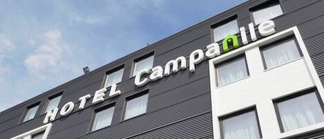 A hotel building with a modern facade, featuring a sign that reads "HOTEL Campanile."