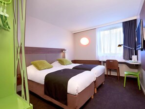 A hotel room with two beds, a desk, a chair, a TV, and a window with curtains. - Campanile Bordeaux Ouest Mérignac Aéroport (Merignac)