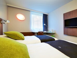 A hotel room with two beds, a desk, a chair, a TV, and a window with curtains. - Campanile Bordeaux Ouest Mérignac Aéroport (Merignac)