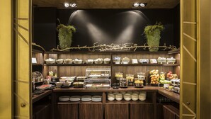 A buffet area with various food items and dishes displayed on wooden shelves.