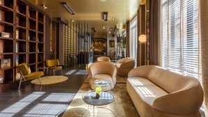 A modern lobby with leather sofas, a coffee table, and a bookshelf.