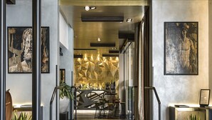 A modern interior with a bar area, staircase, and artwork on the walls.